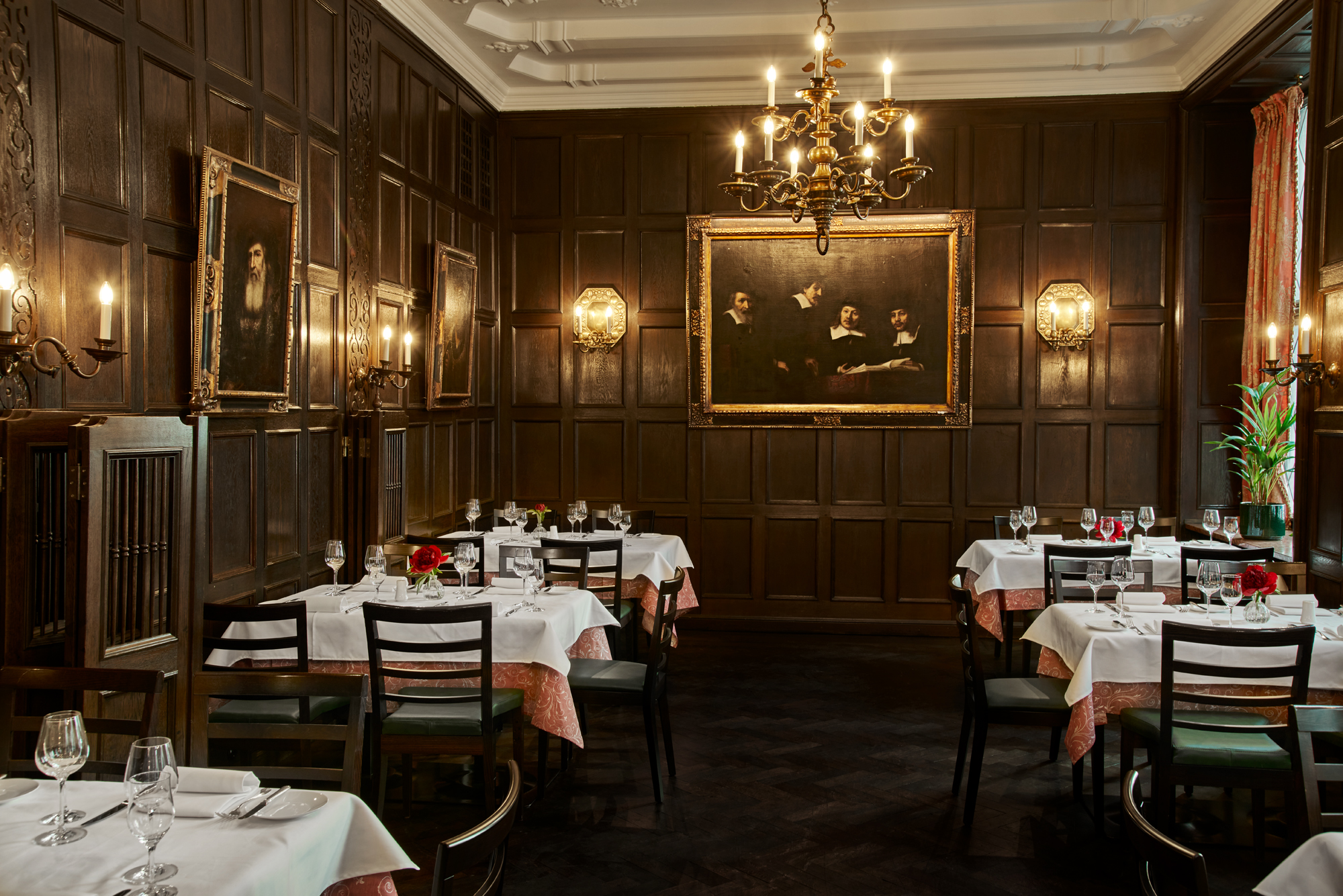 Rembrandtzimmer im Restaurant Central Café , Tische mit weißen Tischdecken, Gläsern und Blumen, Wandleuchten, ein Kronleuchter, Rembrandt-Repliken